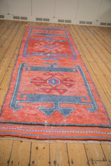 Geometric medallion with crab floral motifs on distressed Kurd runner, faded ruby and royal blue.
