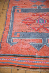 Distressed vintage Kurd runner, faded raspberry red and royal blue geometric hook patterns.