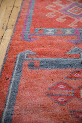 Distressed vintage Kurd runner's faded ruby red, royal blue, and fuchsia geometric design.