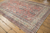 Distressed vintage Sparta rug with faded red palmettes and cream germinating plant border.