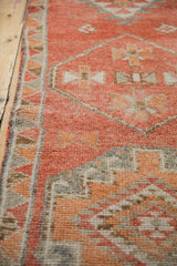Distressed Kurd runner, showing textured pile, zig-zag border in faded rust and time-softened silver.