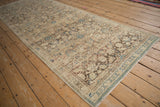 Distressed vintage Hamadan runner corner showing minor blossom border and sapphire blue Herati motif.