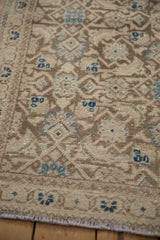 Textured surface of distressed Hamadan runner, dusty chocolate and sapphire blue Herati pattern.