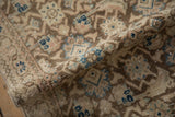 Distressed vintage Hamadan runner's rolled pile, showing brown, ivory, and sapphire Herati pattern.