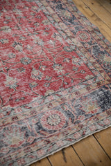 Distressed Sparta carpet texture, showing faded cherry red vinery and a navy blue border.