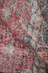 Distressed cherry red and slate blue patterns with visible wear across the vintage Sparta carpet.
