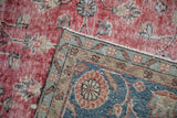 Distressed cherry red field texture of the Sparta rug meets its floral slate blue border.