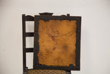 Antique wooden frame's back, revealing its aged brown backing board and wire hanger.