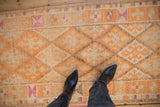 Close-up of the distressed Kurd runner's short pile with a tangerine diamond lattice pattern.