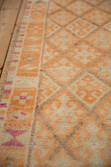 Detail of the short hand-knotted pile on a Kurd rug with geometric tangerine and magenta designs.