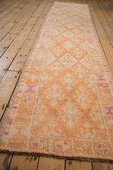 Angled view down the length of a distressed Kurd runner with a tangerine lattice pattern.