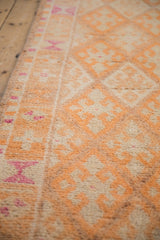 Angled detail of the runner's short pile, showing the faded tangerine and magenta geometric border.