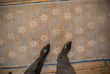 Distressed Oushak runner displaying starburst motifs in pale blue on an abrashed beige field, with blue selvage.