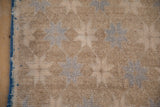 Textured pile of vintage Oushak runner, with distressed beige and pale blue starburst design, blue selvage.