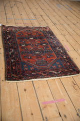 Vintage Borchalou rug from a high angle, showing its complete design with vase motifs on a rust field.