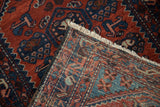 Close-up of the hand-knotted foundation and rust-red pile of a vintage Borchalou rug.