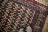 Feet on vintage Afghani Bokhara rug, geometric guls and cherry red border.