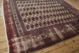 Detail of Afghani Bokhara geometric guls on beige, cherry red, navy border, worn edge.