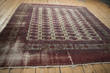 Vintage Afghani Bokhara carpet's red geometric border, guls, and low pile texture.