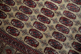 Angled detail of cherry red geometric guls and striped border on a vintage Afghani Bokhara rug.