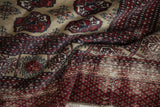 Textured cherry red, navy blue pile and woven foundation of the vintage Afghani Bokhara rug.