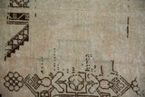 Even wear across the knot heads of a distressed Oushak rug in dusty sandalwood and chocolate brown.