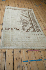 Angled view of a vintage Oushak rug displaying its dynamic color abrasion and stepped medallion.