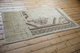 Angled view revealing the dramatic dye lot variations and worn texture of a vintage Oushak rug.