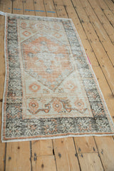 Vintage distressed Oushak runner end with visible knot heads and intricate terracotta border.