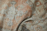 Distressed Oushak rug runner close-up, showing worn dusty terracotta and ivory pattern, foundation visible.