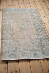 Textural detail of the distressed Sparta rug with faded sand and pale sky blue patterns.