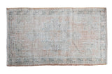 Distressed vintage Turkish Oushak rug, faded medallion, muted coral, ivory, sage green.