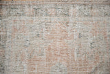 Distressed vintage Oushak rug pile texture showing wear, ivory, coral, sage, and fringe.