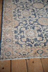 Close-up of distressed vintage Sparta rug showing faded navy and coral pomegranate motifs with foundation wear.