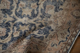 Distressed Turkish Sparta rug with worn navy blue and beige pomegranate vine motifs.