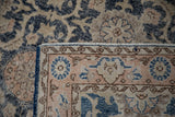 Distressed texture of a Vintage Sparta rug, highlighting navy, pale coral, and beige motifs.