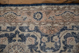 Distressed Sparta rug detail: worn navy, coral, beige floral patterns, visible foundation.