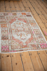 Vintage distressed Oushak rug laid at an angle, revealing a soft patina and faded floral pattern.