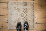 Vintage distressed Oushak square rug detail showing abrashes and geometric starburst motifs.