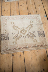 Distressed vintage Oushak rug corner with even wear, faded geometric border, and short fringe.