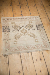 Distressed Oushak rug corner showing fringe, intact selvage, and abrashed geometric motifs.