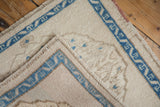 Folded corner of a vintage Oushak rug revealing the hand-knotted foundation and ivory wool pile.