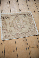 Distressed Oushak rug corner: cream and brown geometric border, even pile wear, intact selvage.
