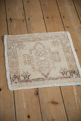 Vintage distressed Oushak mat corner showing antique ivory field, serrated leaf brown border, even wear.