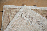 Vintage distressed Oushak rug showing heavy abrashes, exposed foundation, and intact side selvage.