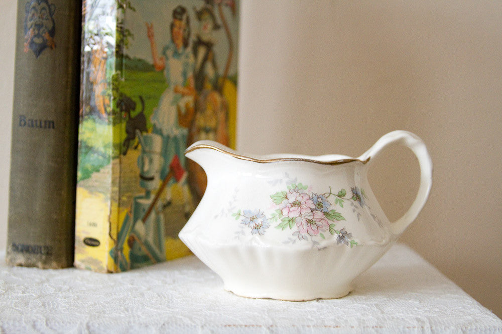 Vintage Homer Laughlin creamer with fluted sides, a pink floral design, and gold rim.