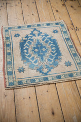 Distressed Oushak rug corner with pale sapphire blue border pattern, short pile, and madder red selvage.