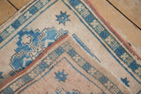 Vintage distressed Oushak rug reverse with painted numbers, blue starburst motif, and red selvage.