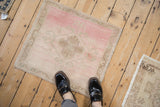 Distressed Oushak mat shown for scale, featuring a blush pink and sand medallion on the floor.