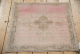 Distressed Oushak square mat showing a time-softened palette of blush pink, sand, and ivory tones.